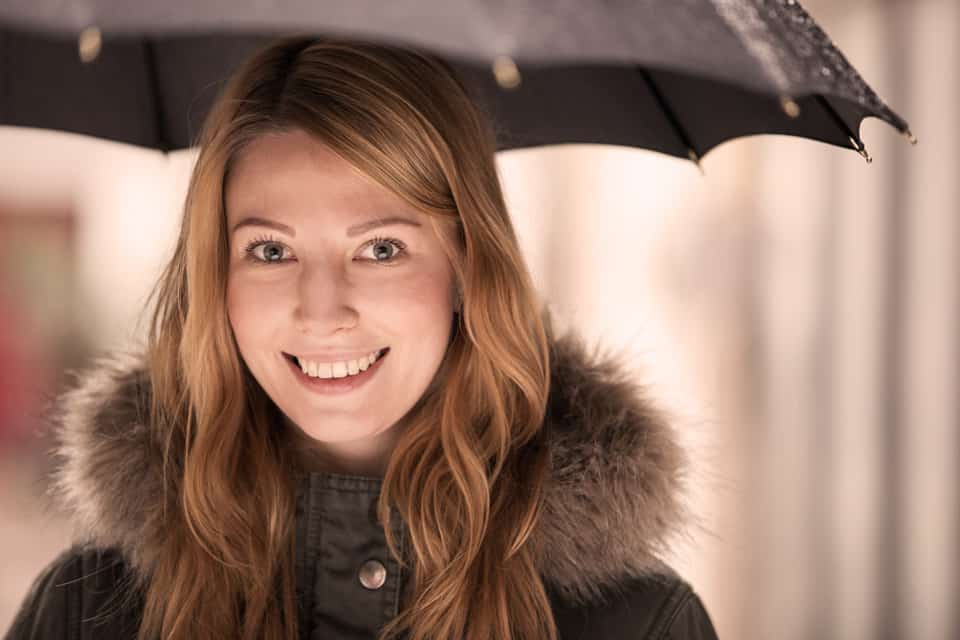 lächelnde Frau mit Regenschirm